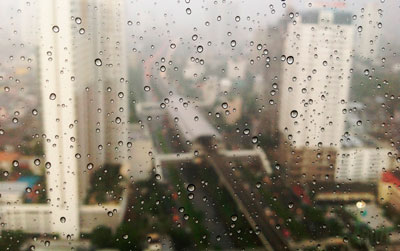 Вид на город через окно во время дождя